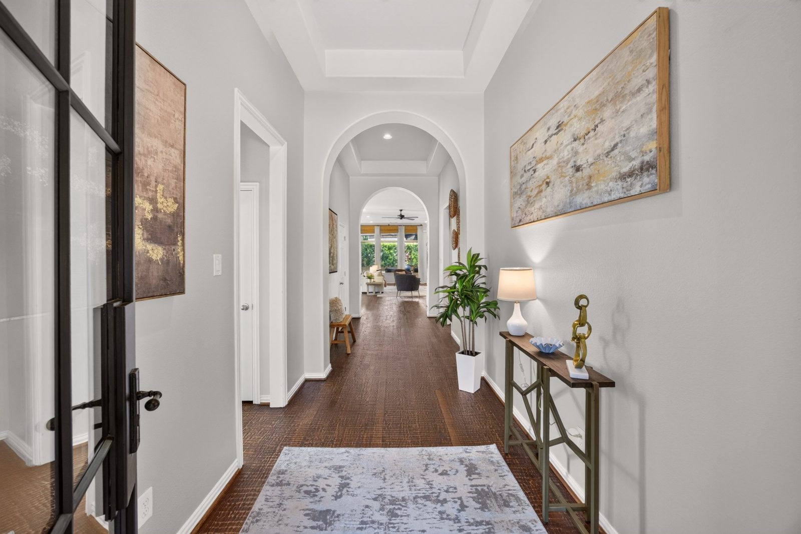 Entry hallway with arched doorways and wood floors